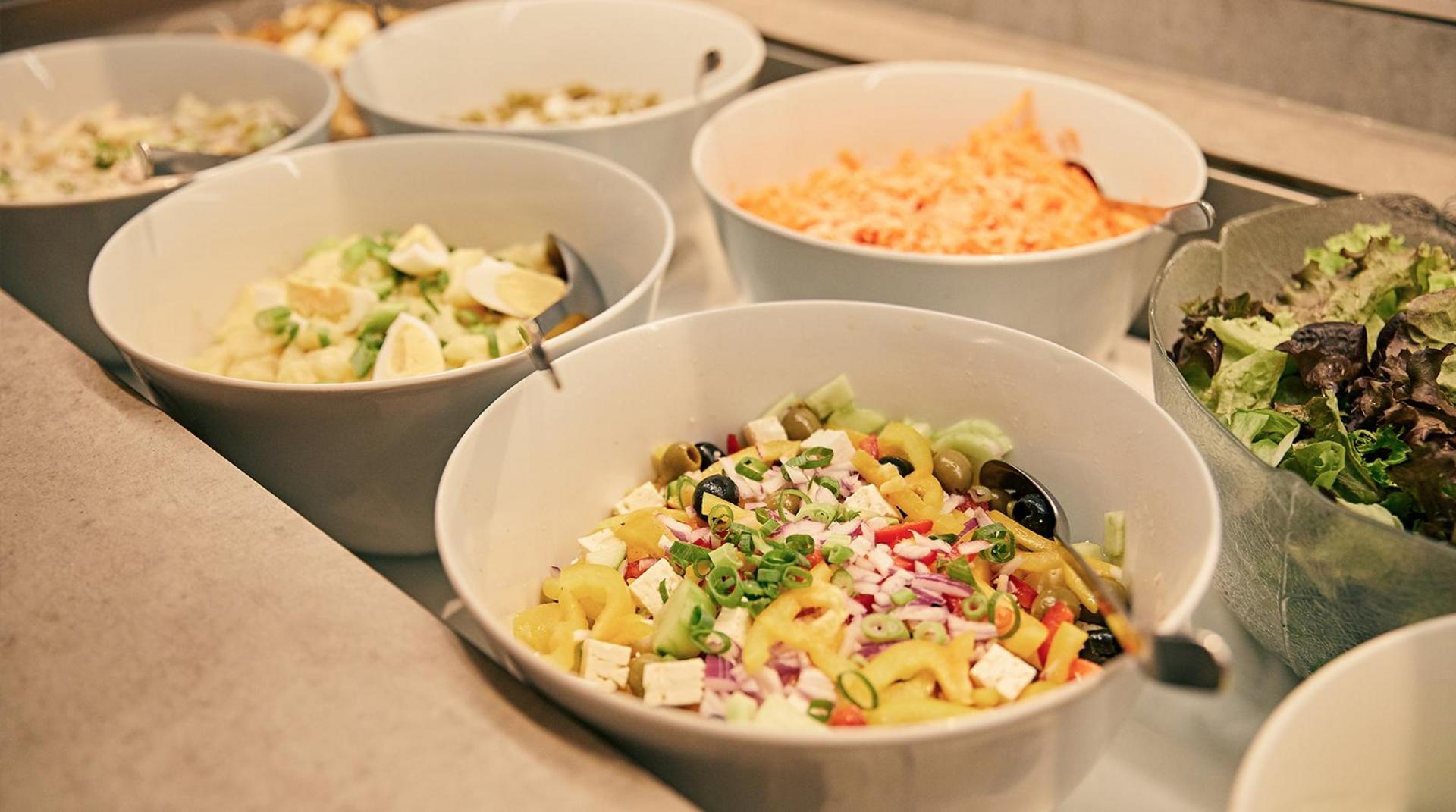 Schalen mit verschiedenen frischen Salaten am Buffet