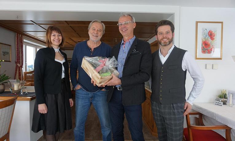 Schauspieler Gerd Silberbauer zu Gast im Hotel Birkenhof in Oberstaufen, gemeinsam mit Gastgebern bei Geschenkübergabe