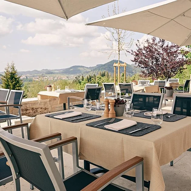 Tisch auf der Panoramaterasse und Blick auf die Berge und Oberstaufen im Hintergrund