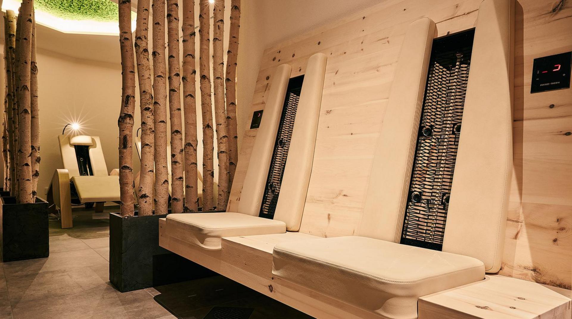 NaturSpa mit modernen Infrarotliegen aus Holz, umgeben von Birkenstämmen im Hotel Birkenhof Oberstaufen.
