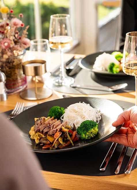 Fein angerichtetes Gericht mit Reisnudeln, Gemüse, Brokkoli und Rindfleisch im Restaurant des Hotel Birkenhof Oberstaufen.
