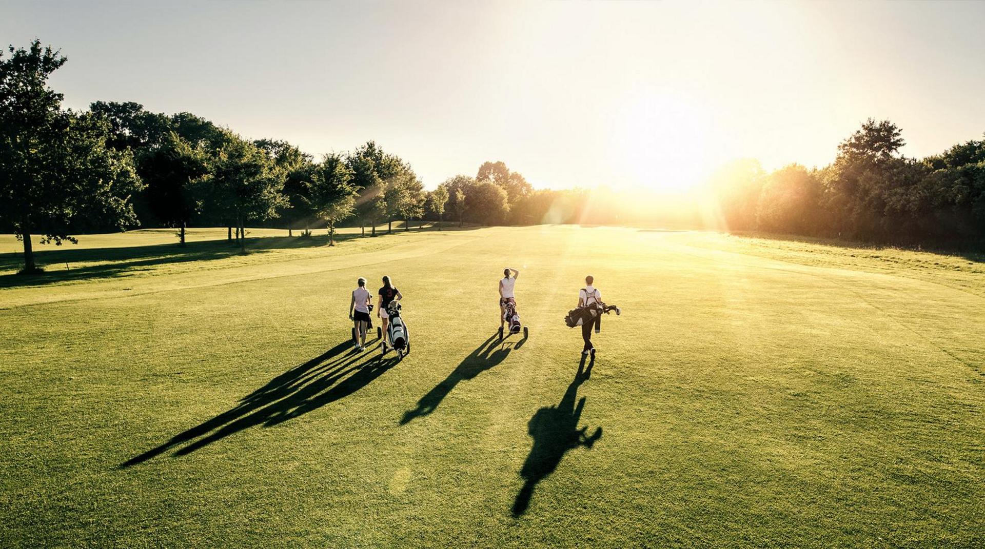Golfspieler auf Greenfee bei Sonnenuntergang