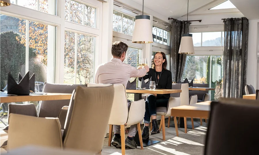 Paar sitzt an einem Tisch in einem Restaurant und genießt ein gemeinsames Essen