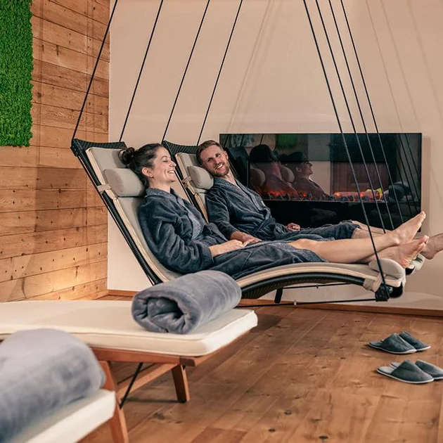 Paar entspannt in Schwebeliegen im Wellnessbereich des Hotel Birkenhof Oberstaufen im Allgäu