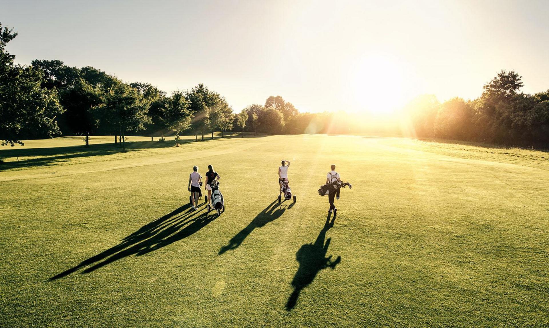 Golfspieler auf Greenfee bei Sonnenuntergang