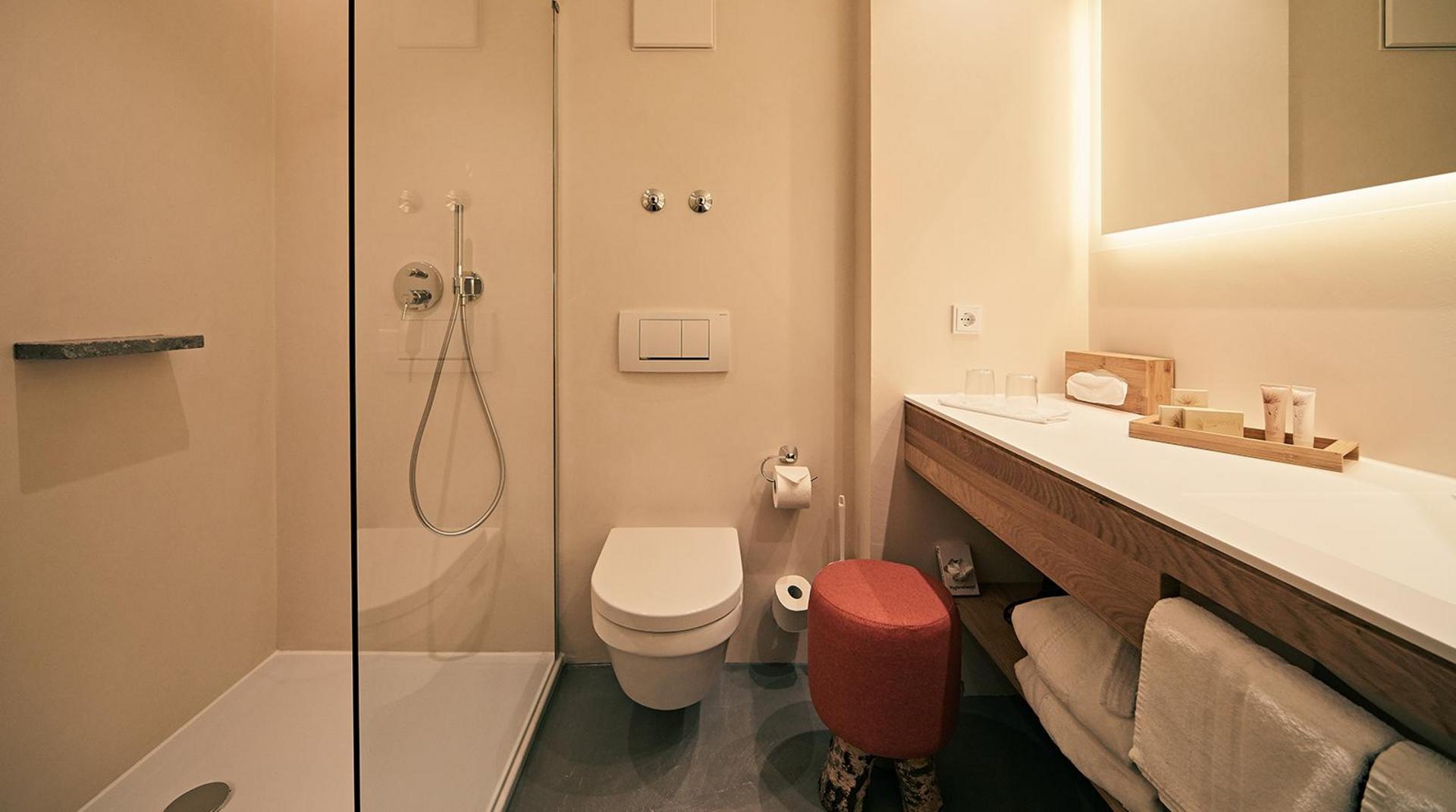Helles Bad mit großer Dusche, WC und langem Waschtisch.