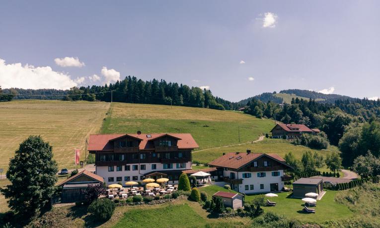 Hotel Birkenhof in Oberstaufen mit Sonnenterrasse, umgeben von grünen Allgäuer Wiesen und Bergen
