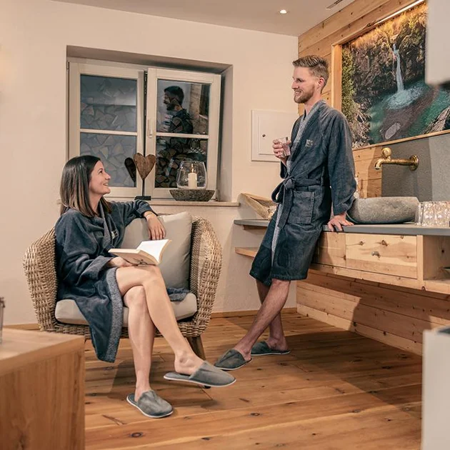 Paar im Bademantel genießt einen Tee im Ruhebereich des Hotels