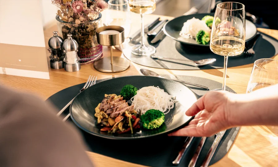 Fleischgericht mit Gemüse, Brokkoli und Kartoffelstampf auf schwarzem Teller.