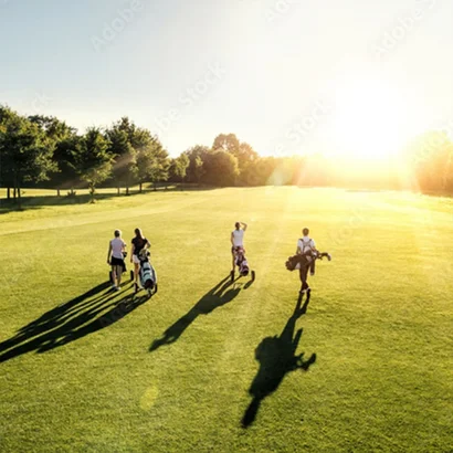 Gruppe von Golfern geht über den sonnigen Golfplatz bei Oberstaufen im Allgäu