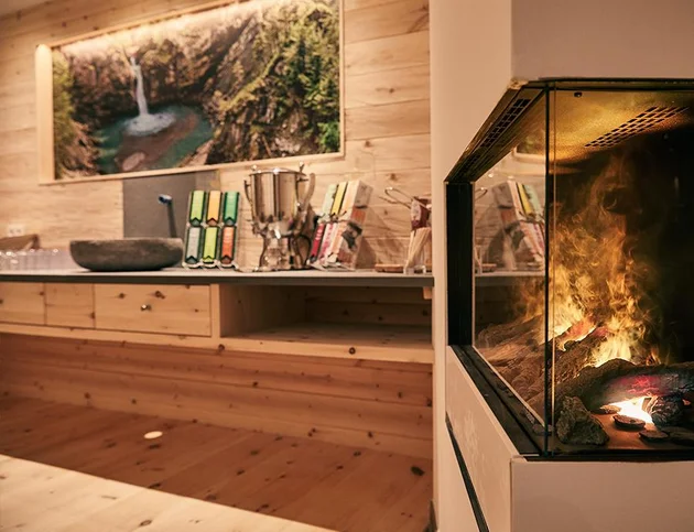 Gemütlicher Spa-Bereich mit Getränkestation und Kamin.