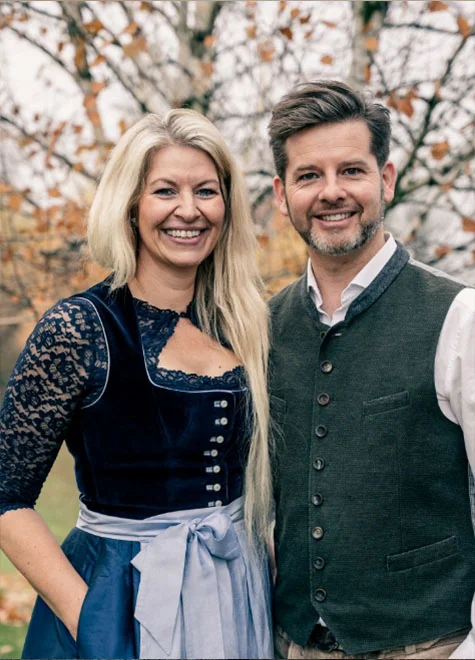 Gastgeberpaar des Birkenhofs: blonde Frau im Dirndl und brünetter Mann.