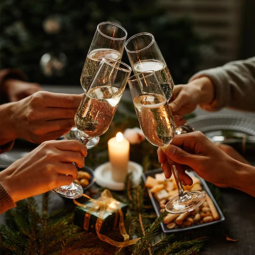 Vier Menschen stoßen mit Sektgläsern auf Weihnachten an
