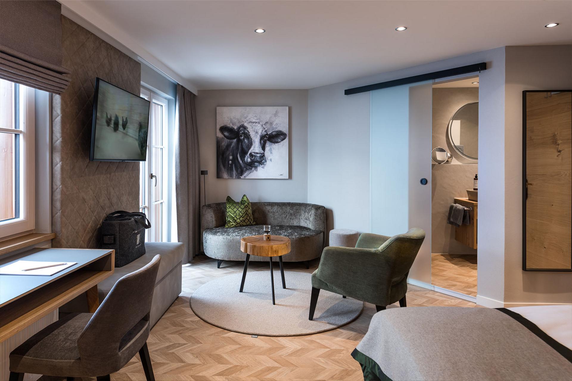 Doppelzimmer_Hochgrat_Hotel_Birkenhof_Oberstaufen_Allgaeu Gemütlich eingerichtetes Doppelzimmer im Hotel Birkenhof Oberstaufen mit Sitzecke, Schreibtisch, Fernseher und Blick ins Badezimmer