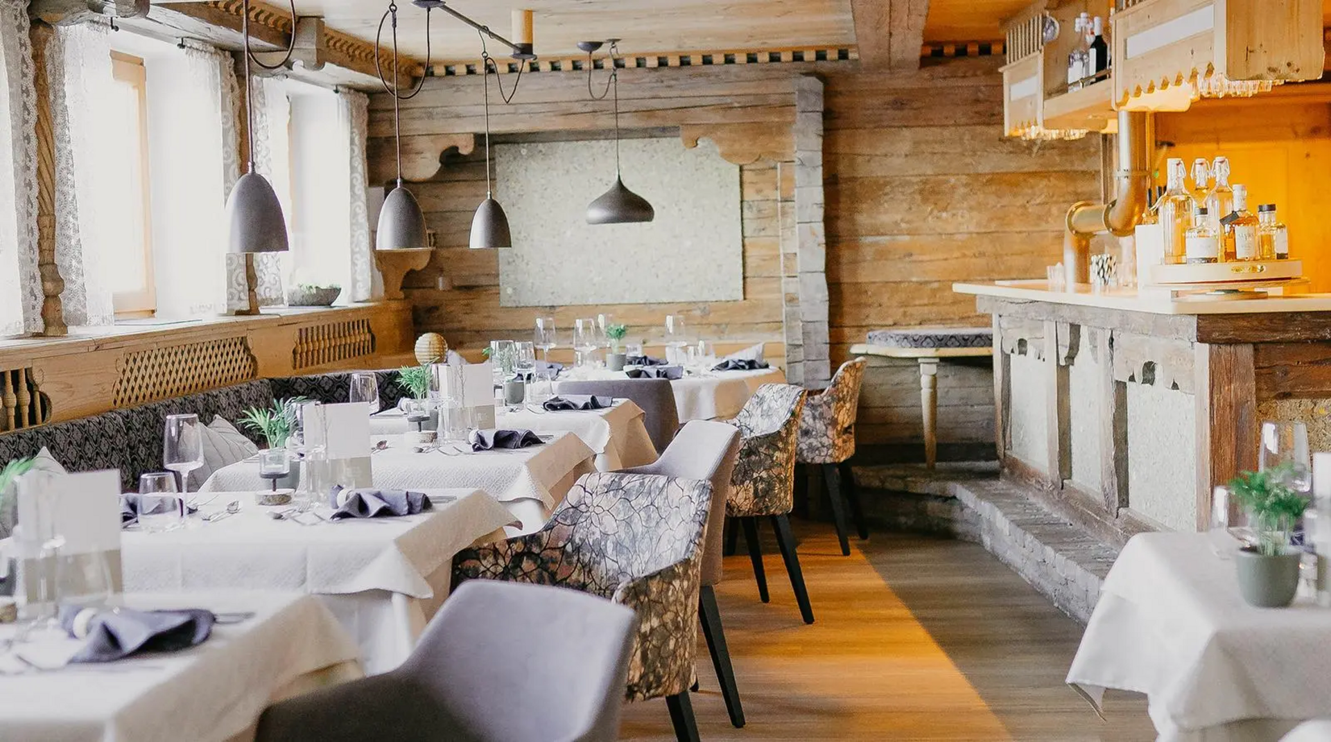 Neue Gaststube im Hotel Birkenhof Oberstaufen mit gedeckten Tischen, Holzverkleidung und moderner Alpenstil-Einrichtung.