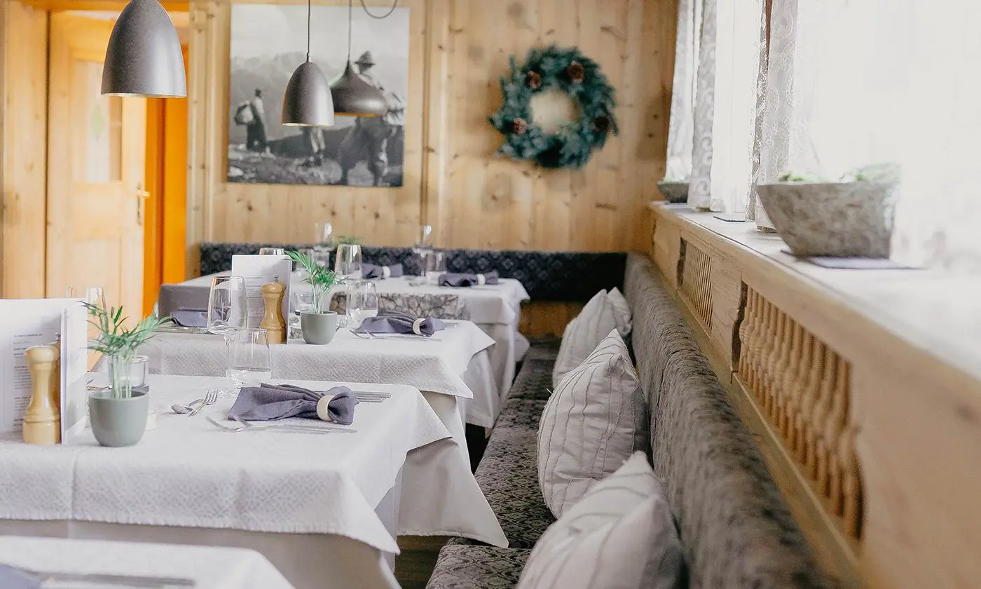Stilvoll gedeckte Tische mit gemütlicher Eckbank und dekorativem Alpenflair im Restaurant des Hotel Birkenhof in Oberstaufen