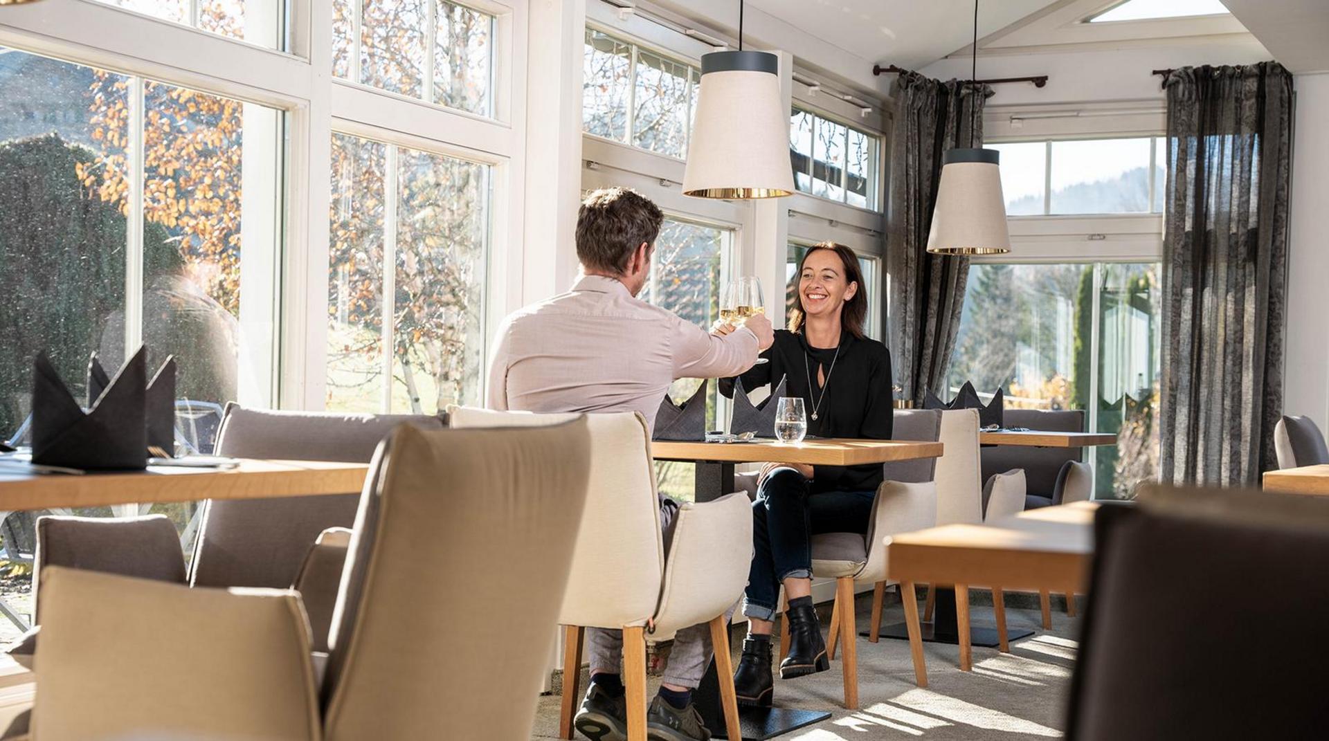 Paar genießt ein Glas Wein im Wintergarten des Restaurants