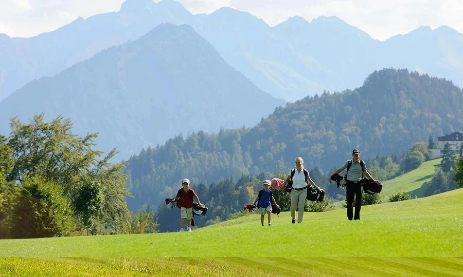 Familie beim gemeinsamen Golfen mit Blick auf die Allgäuer Alpen nahe dem Birkenhof.