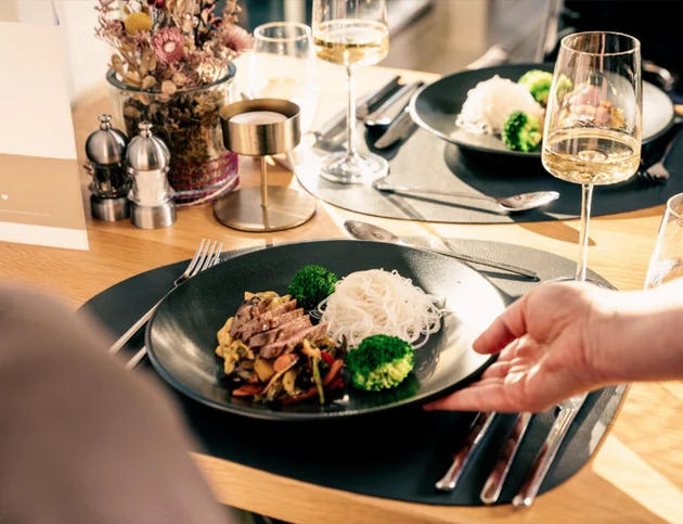 Ansprechend angerichtetes Hauptgericht mit Nudeln, Gemüse und Fleisch auf schwarzem Teller, serviert im Restaurant des Hotel Birkenhof.