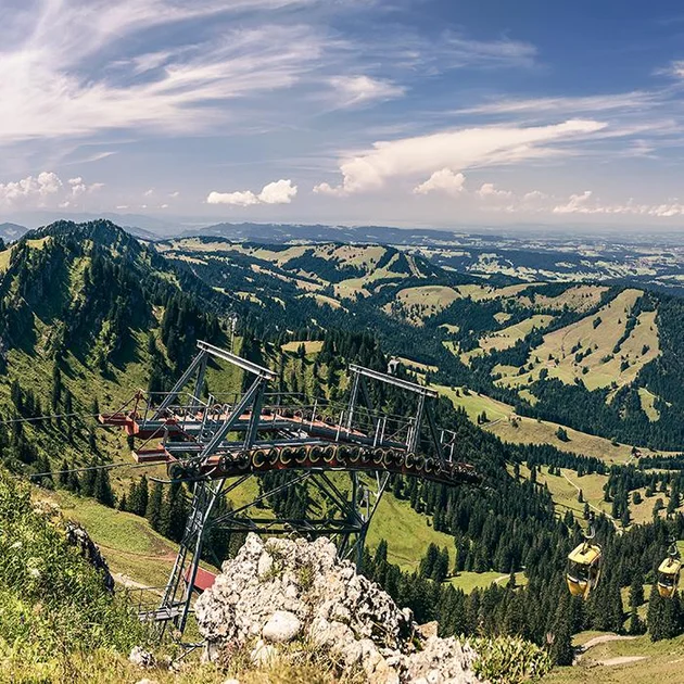 Aussicht auf die Bergbahnen und grüne Hügellandschaft in Oberstaufen