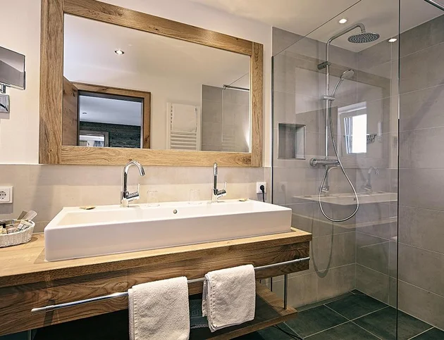 Helles Badezimmer mit großer Dusche, Doppelwaschbecken und Holzdetails