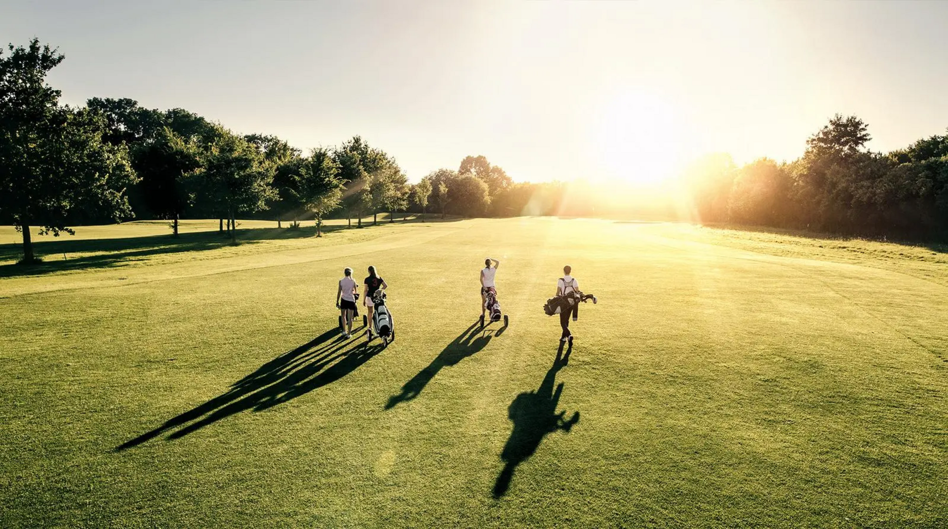 Golfspieler auf Greenfee bei Sonnenuntergang
