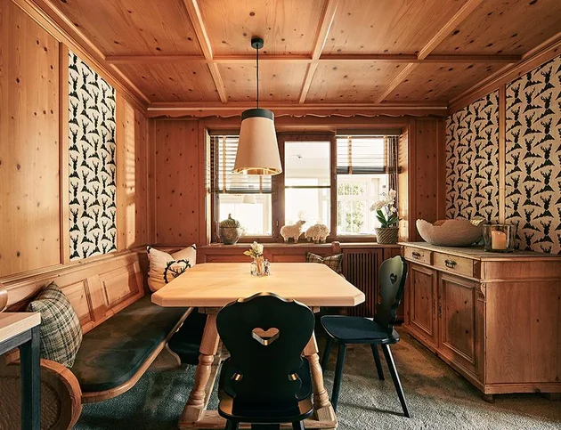 Traditionell eingerichtete Stube mit Holzvertäfelung, großem Esstisch und gemütlicher Eckbank.