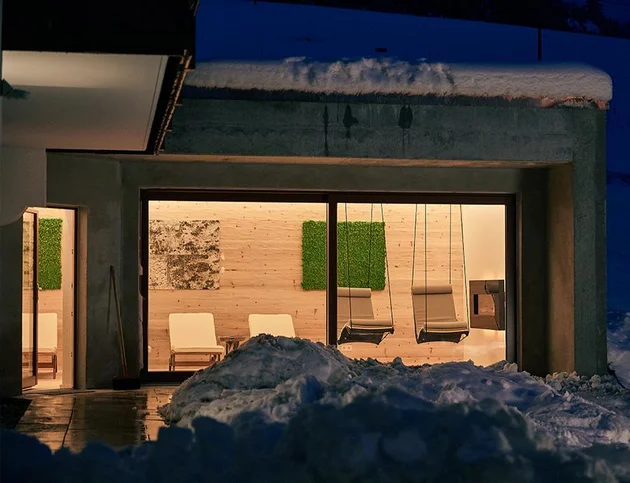 Spa-Ruheraum im Winter, von außen bei Nacht beleuchtet.
