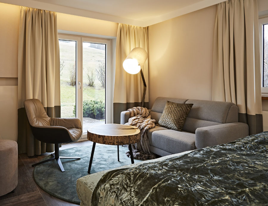 Doppelzimmer mit gemütlicher Sitzecke, modernem Sessel und Sofa.
